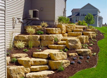 Boulder retaining walls with staircase on side yard