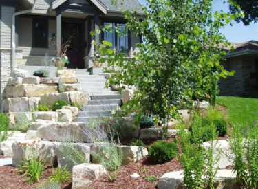 Stone stairway and boulder wall front entry