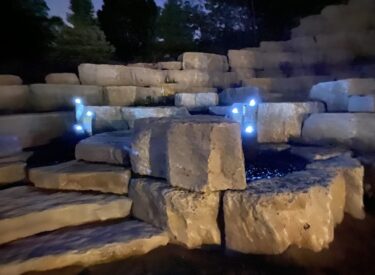 Boulder retaining walls with water feature lighted